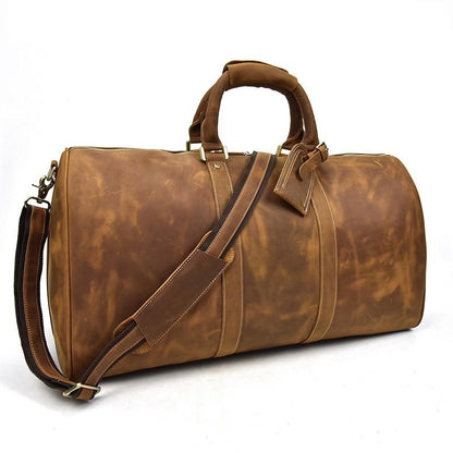 Brown leather duffel bag with shoulder strap on a white background