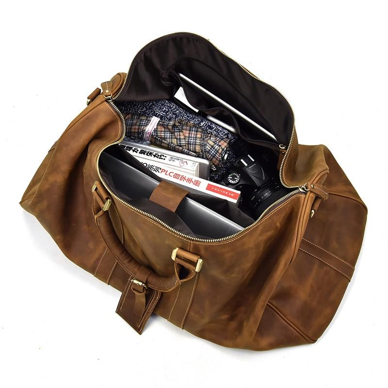 Brown leather duffel bag with items inside on a white background