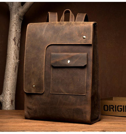 Brown leather backpack on a wooden surface with a brown background
