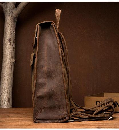 Brown leather bag with strap on a wooden surface against a brown background