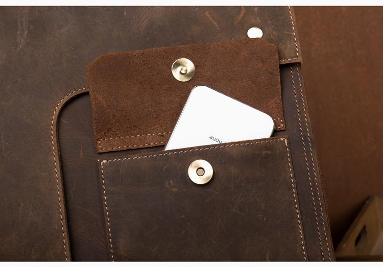 Close-up of a brown leather pouch with a card inside, on a matching brown background.
