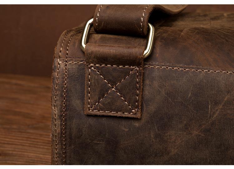 Close-up of a brown leather bag with stitching detail on a wooden surface