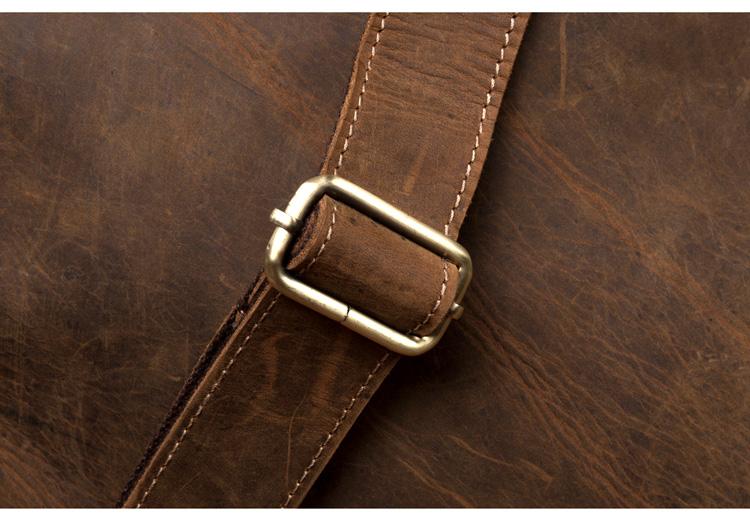 Close-up of a brown leather bag with a gold buckle.