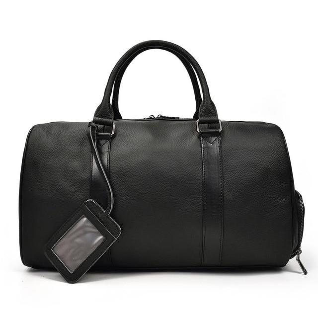 Black leather duffel bag with a shoulder strap on a white background