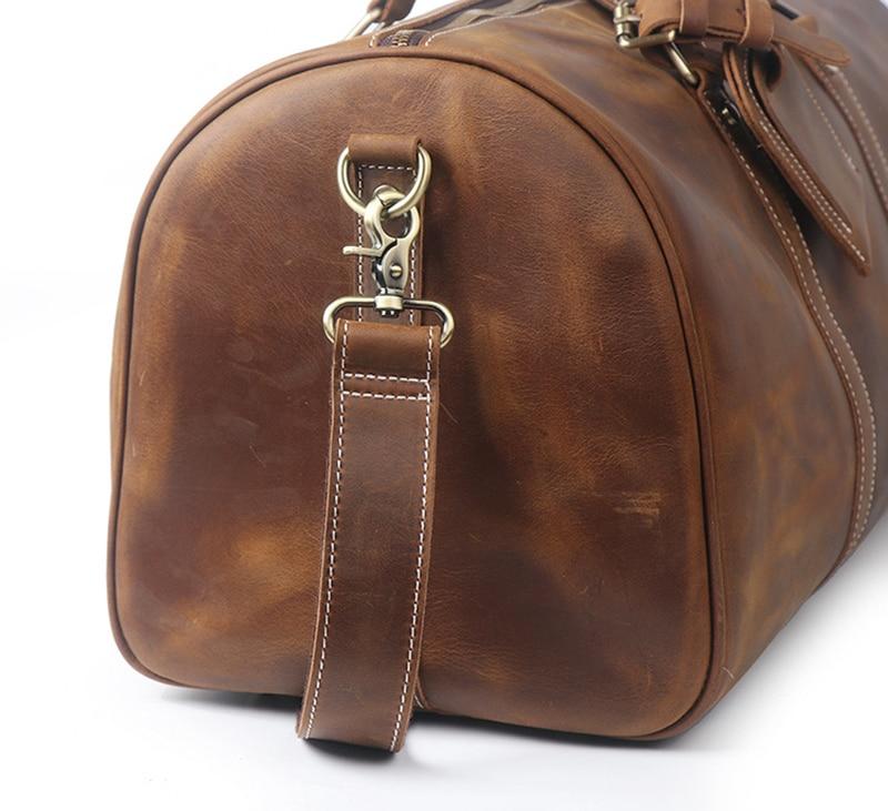 Brown leather duffel bag with a strap on a white background