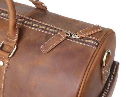 Brown leather bag with gold zipper and hardware on a white background