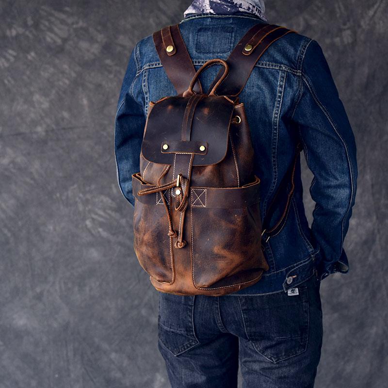 Person wearing a brown leather backpack with a gray background