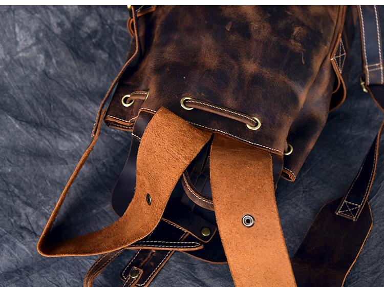 Brown leather bag with a strap on a textured blue background