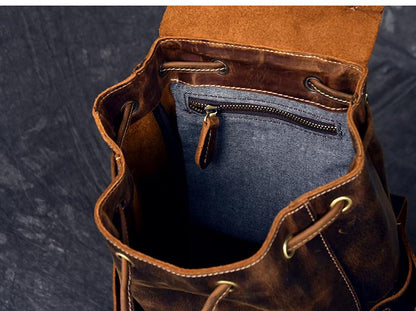 Brown leather bag with blue interior and gold zipper on a dark background
